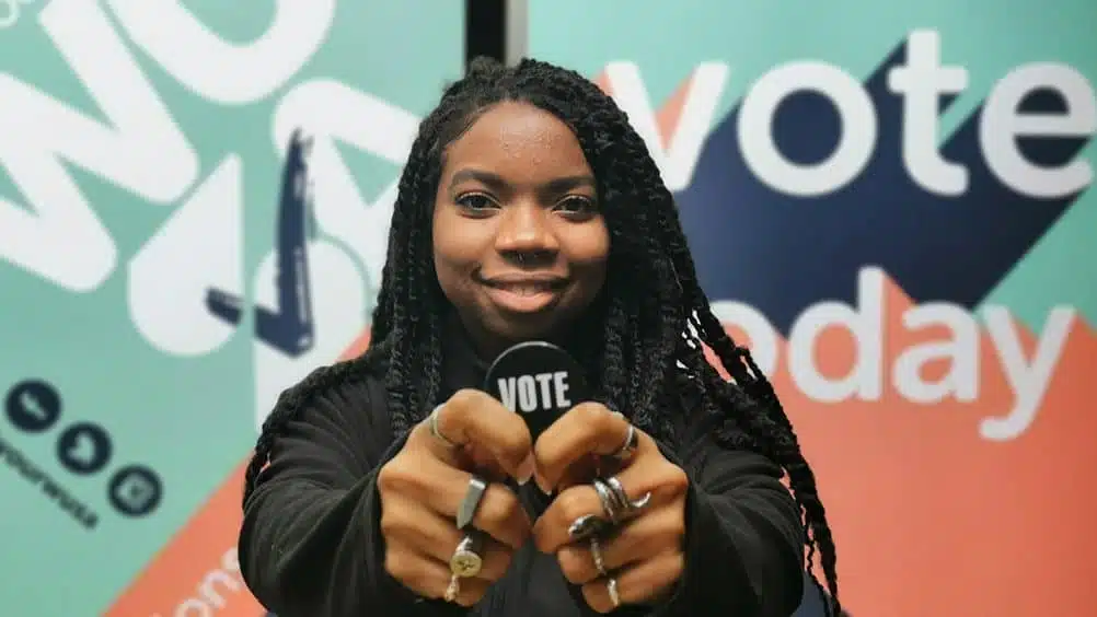 Student holding a vote pin at a WUSA Election booth.