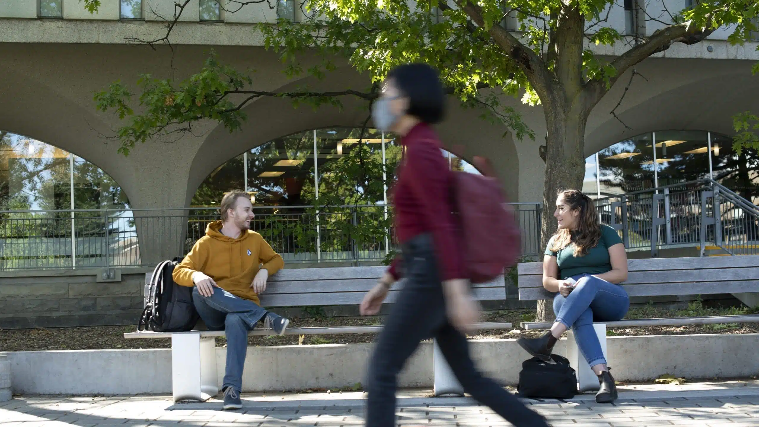 Students walking across campus library, Dana Porter Library, University of Waterloo