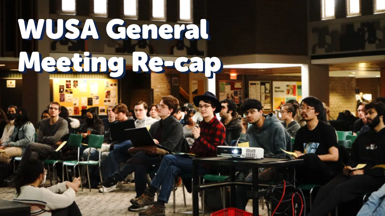 A group of people seated in rows indoors, attentively listening to a presentation. Some are holding notebooks and laptops. The brick walls and informational posters in the background suggest an academic environment. Text overlay reads, "WUSA General Meeting Recap.