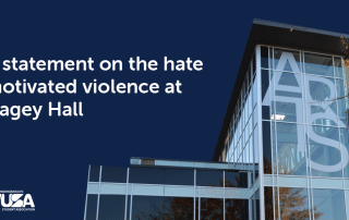 A modern glass building with large white letters "ARS" on the facade stands beside bold text stating, "WUSA statement on the hate motivated attack at Hagey Hall." The Waterloo Undergraduate Student Association (WUSA) logo is at the bottom left.