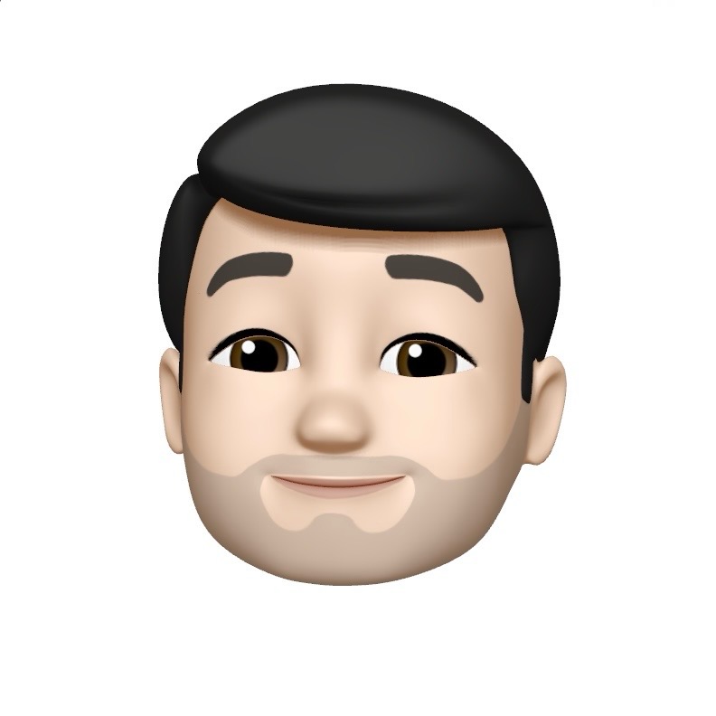 Animated emoji of a person's face with dark hair and a short beard. The facial expression is neutral with a slight smile, brown eyebrows, and brown eyes. The background is plain white.