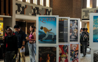 Students viewing posters for bands and movies in the Student Life Centre, University of Waterloo