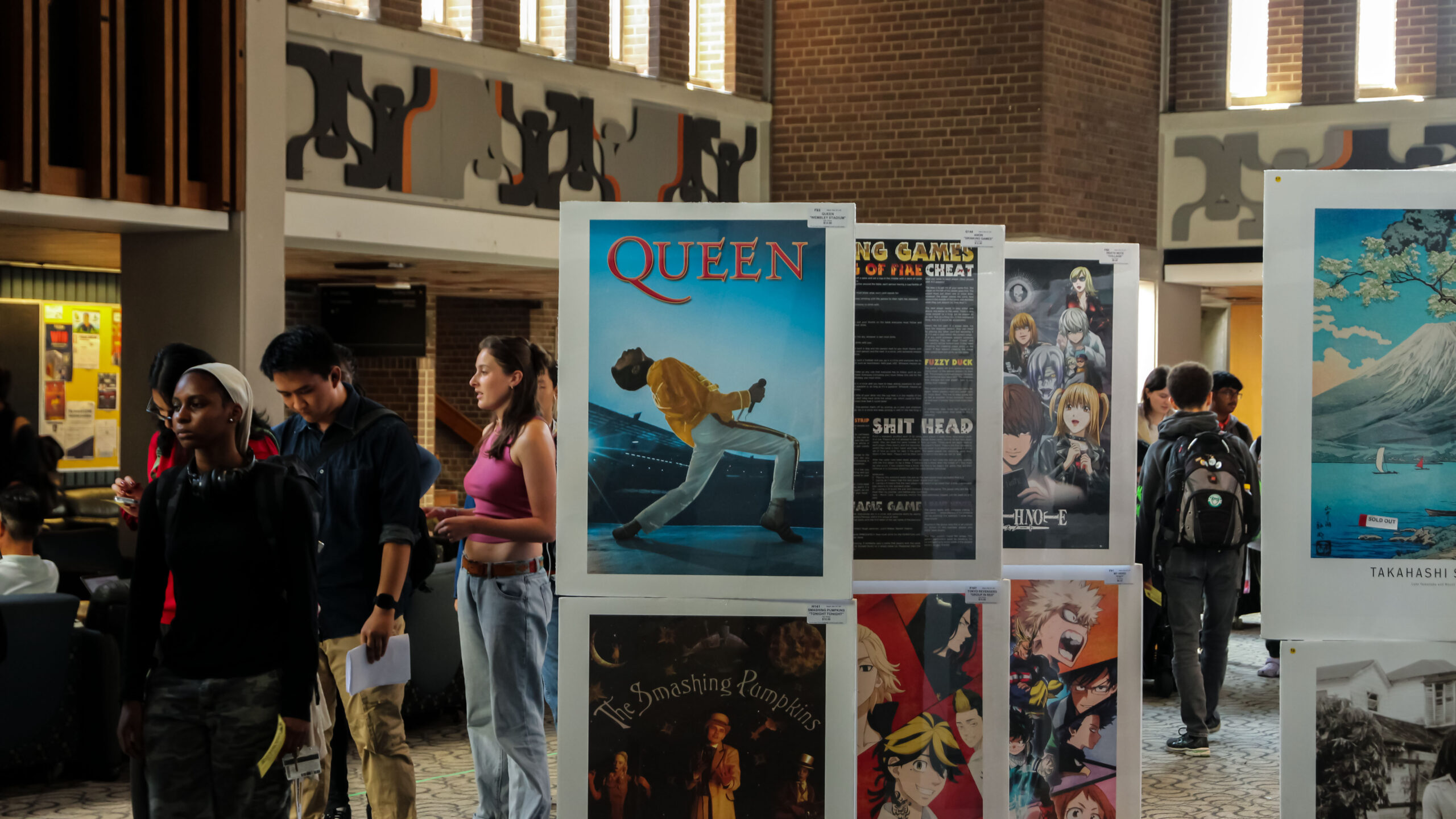 Students viewing posters for bands and movies in the Student Life Centre, University of Waterloo