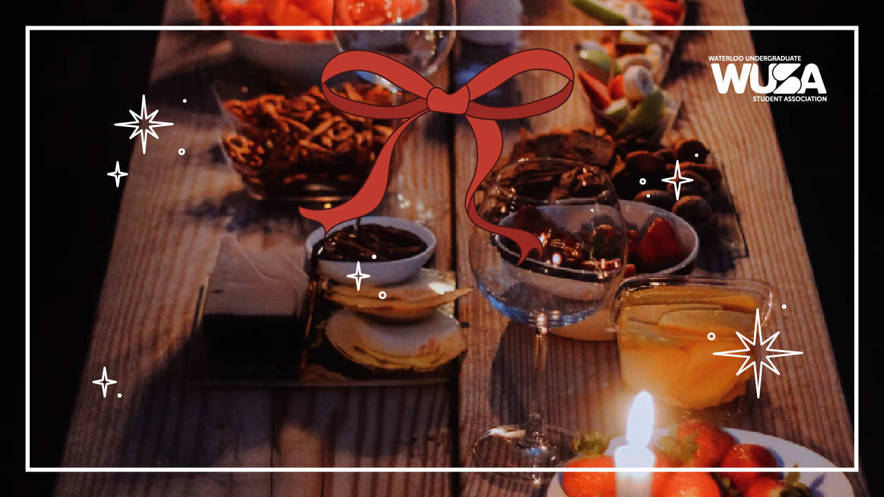 Festive table with snacks, candles, and drinks, adorned with a ribbon graphic on a dark wooden surface.