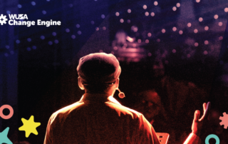 At a vibrant Live Competition Night, a speaker with a headset captivates the audience amidst decorative stars and circles.