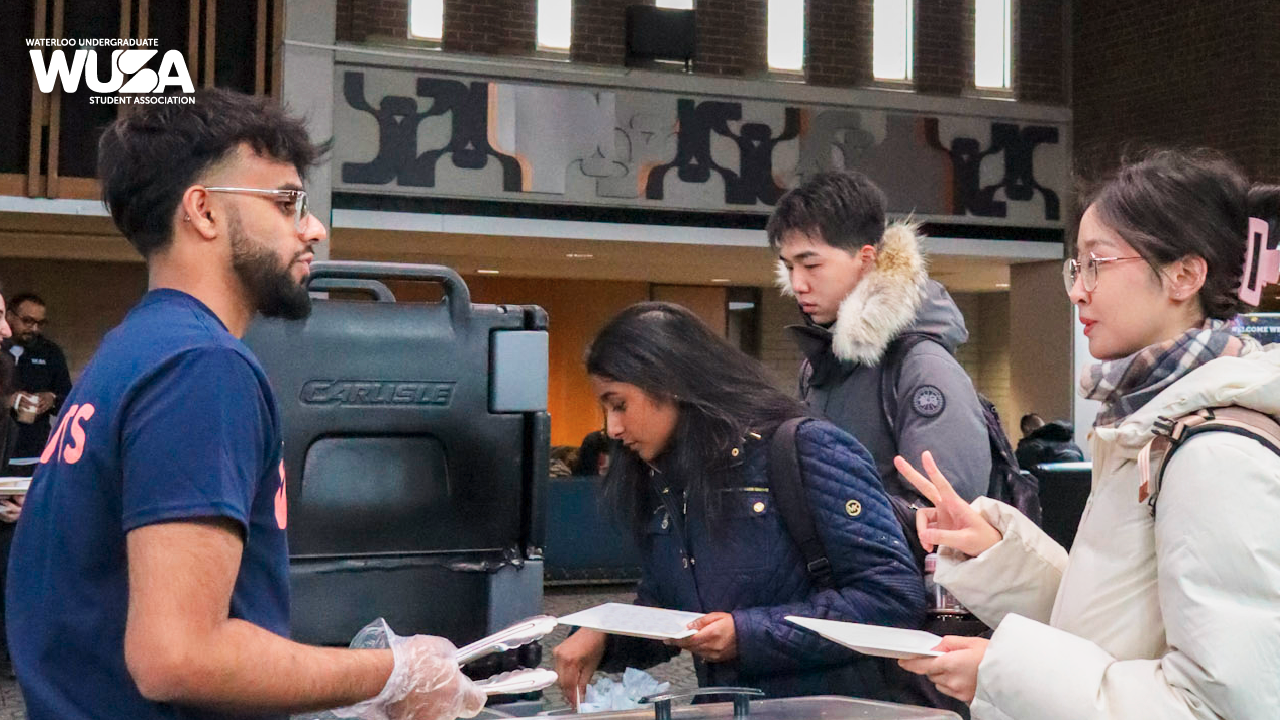 Students, clad in winter clothing, gathered at the counter for a warm welcome brunch during the campus event.