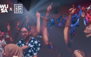 A lively party scene unfolds with people dancing under colorful lights, where the WUSA and UWCSA logos gleam prominently, creating an electrifying ambiance reminiscent of a Lunar Lights Out celebration.