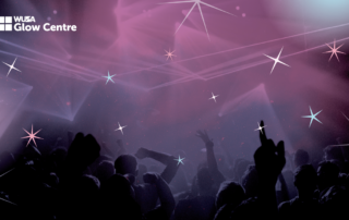 A lively dance floor at the Lavender Ball, with vibrant lights and silhouettes of people dancing under star-like effects.