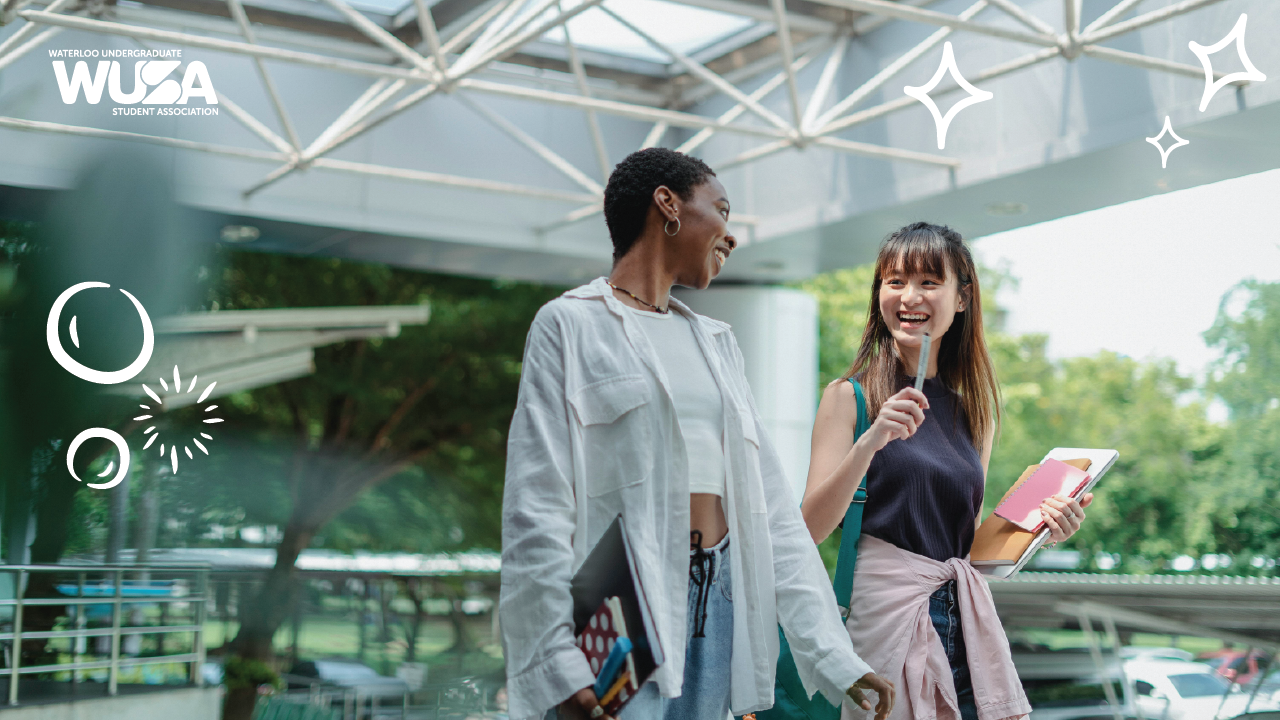 Two students, smiling and holding books, walk confidently outside a modern building adorned with decorative graphics. Their vibrant energy reflects the spirit of a Safer Campus where Your Voice is always heard and valued.