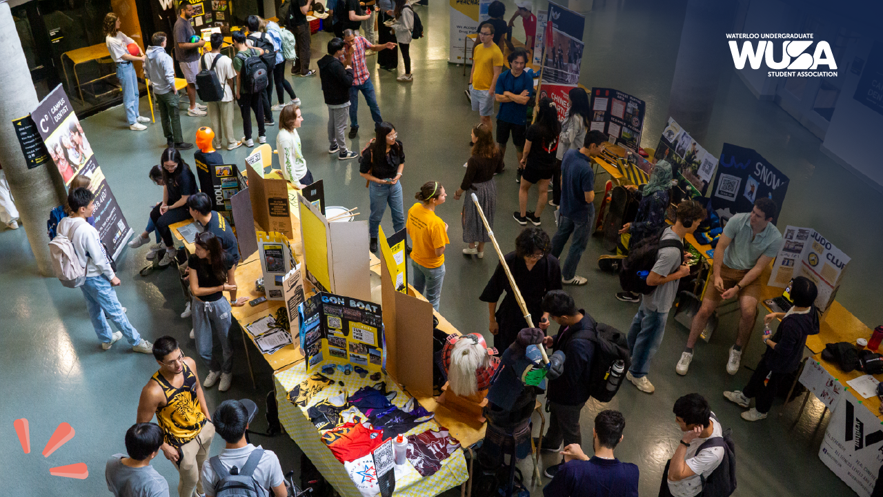 Aerial view of a bustling WUSA club fair with students visiting various booths in a large indoor space, eagerly nominating peers for the upcoming Volunteer Appreciation Awards.