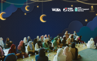 People sitting on the floor at an Iftar event with a night sky and crescent decorations, fostering a sense of connection. Food and drinks are placed in front, inviting reflection and togetherness.