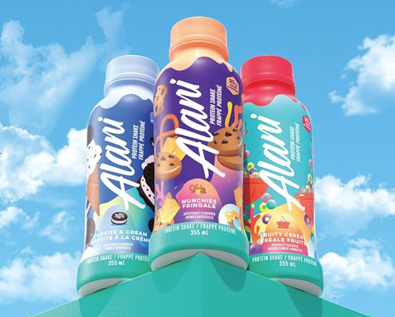 Three vibrant Alani protein shake bottles set against a sky backdrop, featuring irresistible fruit and dessert flavors.