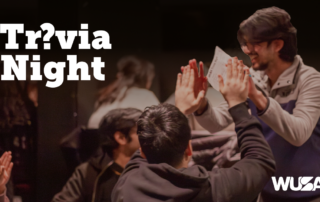 People high-five at a lively Trivia Night event, with bold "Trivia Night" text and the WUSA logo displayed.