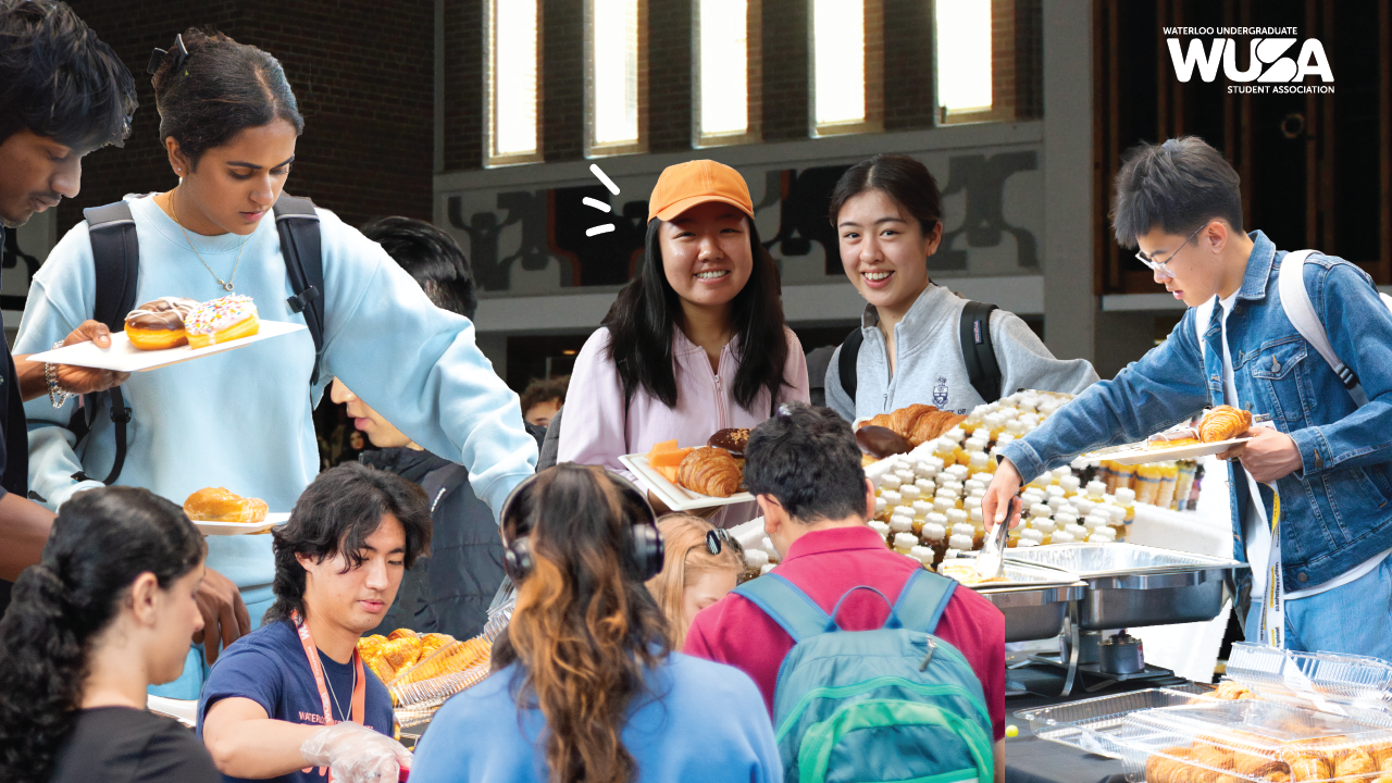 Students gather around tables at the Welcome Brunch, selecting pastries and food, smiling and socializing at this lively campus event.