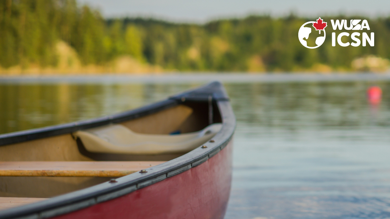 A red canoe rests on a calm lake beneath the WUSA ICSN logo in the top right corner, capturing the spirit of Canoe the Grand.