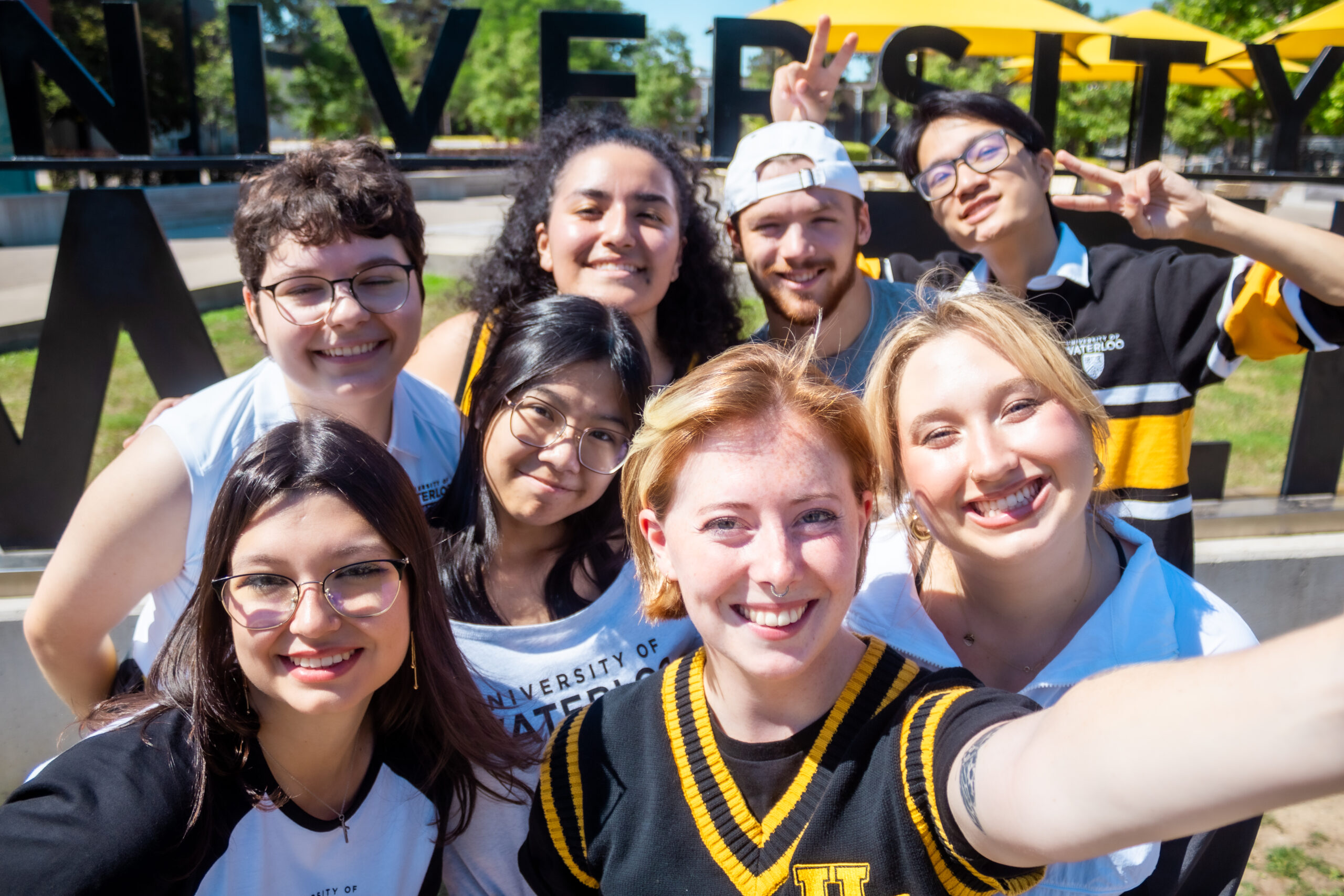 TBH cast selfie in front of the University of Waterloo sign