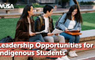 A group of three students sitting outside.