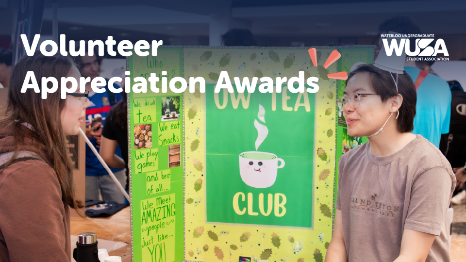 Two students talk at an event booth for OWL TEA CLUB, with a WUSA Volunteer Awards banner celebrating Student Excellence above.