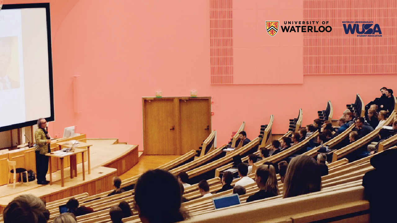 Meet your Directors Promo Version 1_Article Graphic A group of thirteen people pose together on campus in front of a colorful background with the WUSA logo in the corner, highlighting their connection to student services.