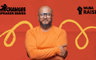 A man in orange stands with folded arms in front of “XChanges Speaker Series” and “WUSA Raise” logos on red, highlighting the theme of Mentorship Through Play.