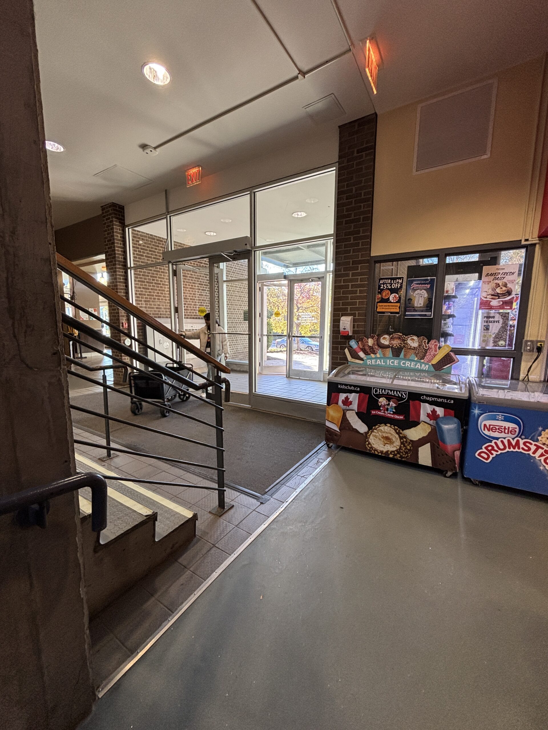 Ice cream freezer near the stairs and glass doors in the SLC lobby, with sunlight streaming through the entrance.
