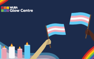 Two hands hold transgender pride flags during a vigil; lit candles and rainbows glow in the background, honoring Transgender Remembrance. The Glow Centre logo is visible.