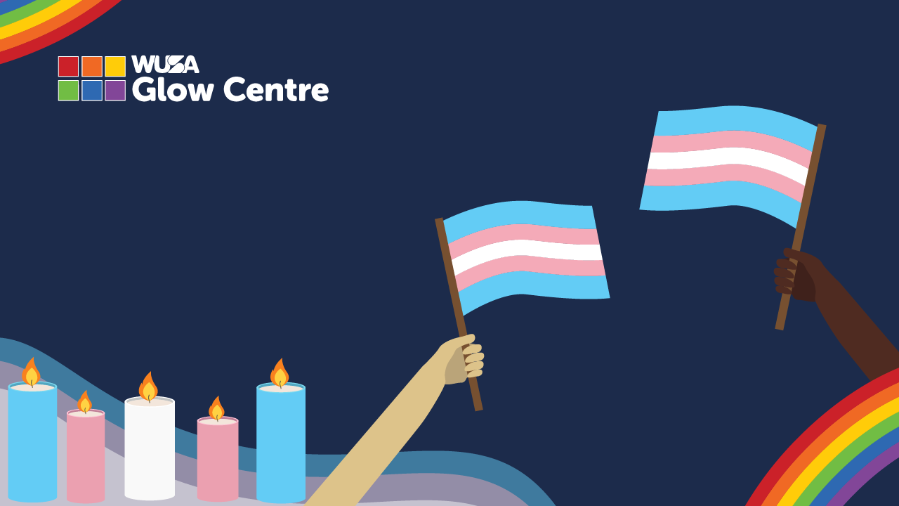 Two hands hold transgender pride flags during a vigil; lit candles and rainbows glow in the background, honoring Transgender Remembrance. The Glow Centre logo is visible.