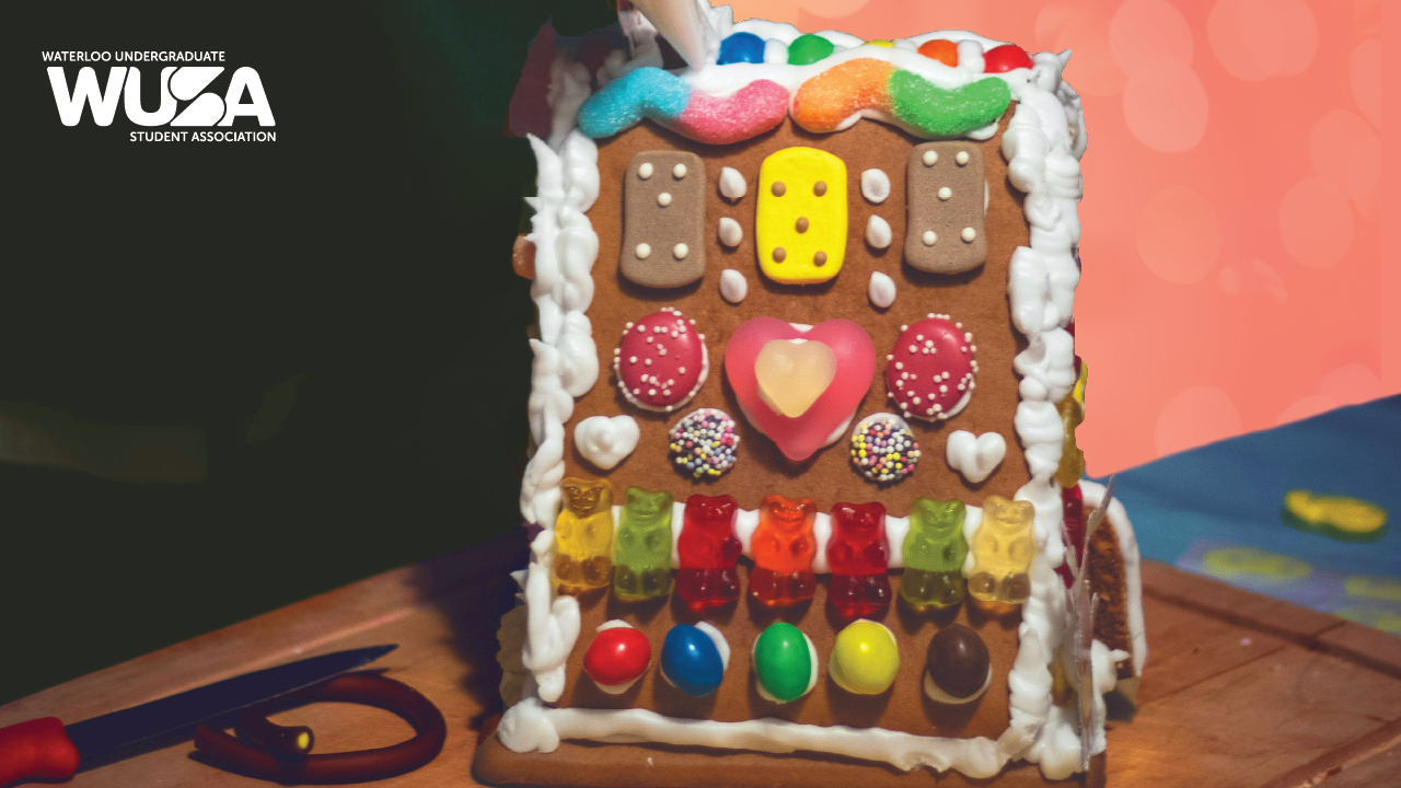 A gingerbread house decorated with colorful candies and icing on a wooden table; WUSA logo in top left corner.