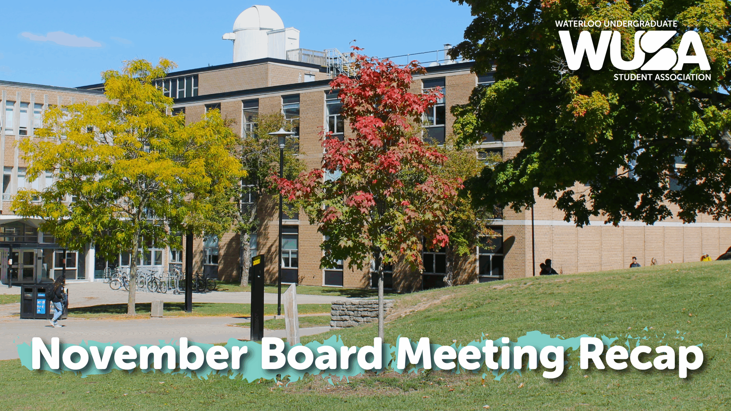 A campus building with autumn trees and text reading "November Board Meeting Recap.
