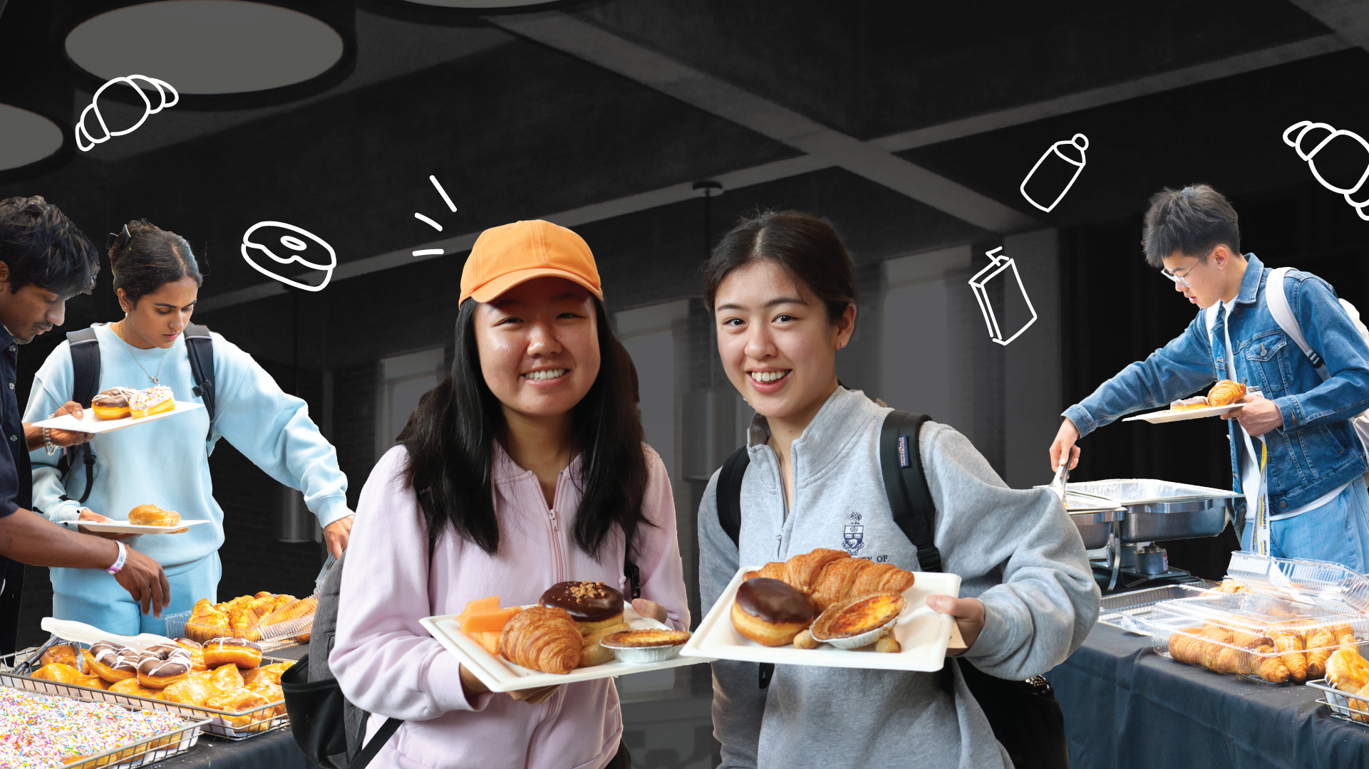 Two students smile holding plates of pastries at the Welcome Brunch buffet, with others serving themselves in the background.