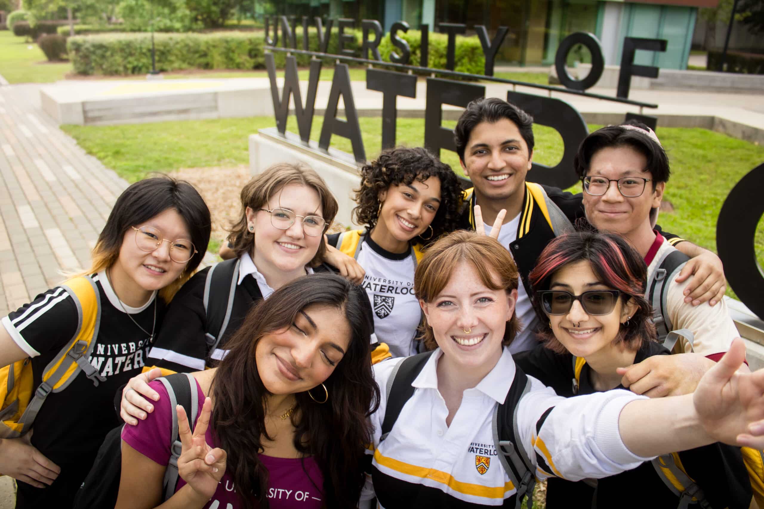 TBH cast selfie in front of the University of Waterloo sign
