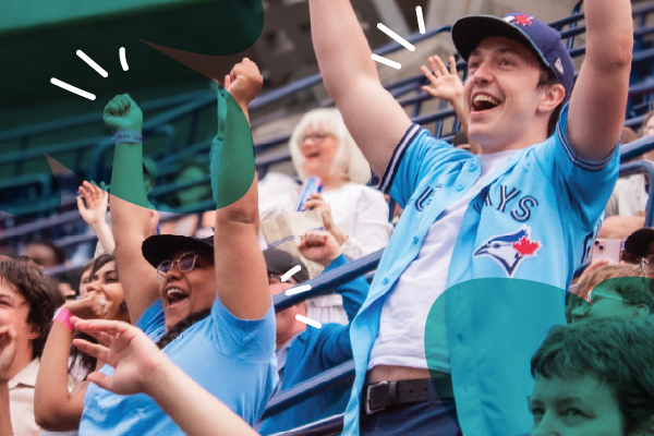 Fans in blue jerseys cheer and celebrate enthusiastically at a baseball game in a crowded stadium, capturing the spirited energy of Welcome Week.