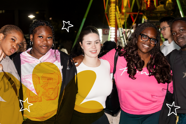Five smiling teens pose together at a nighttime fair during Welcome Week, with a ferris wheel and lights sparkling in the background.
