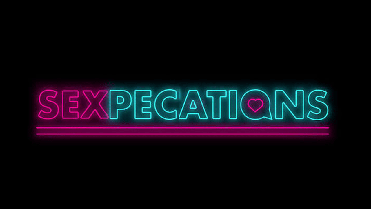 Neon sign reads “SEXPECTATIONS”—with “SEX” in pink and the rest in blue, heart shape inside the “Q”—perfect for a Sexpectations Trivia Night at your local Women’s Centre.